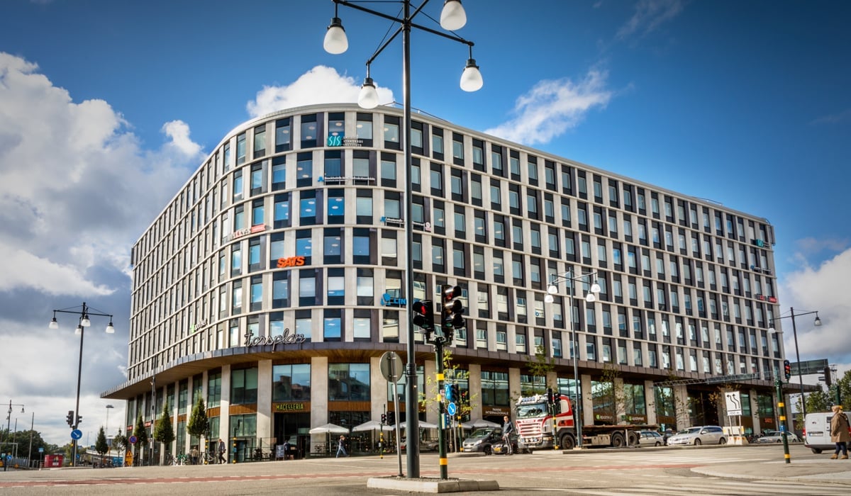 En hög byggnad som ligger i hörnet av en gata.